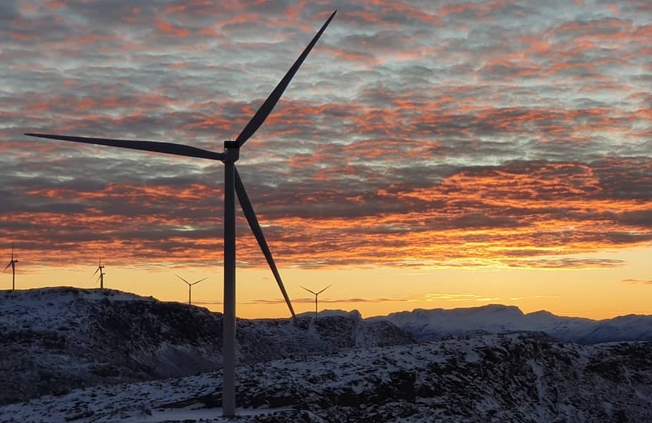 Windmills in sunset with mountains and clouds