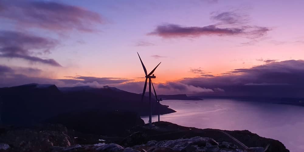 Windmill with mountains and fjords in the background