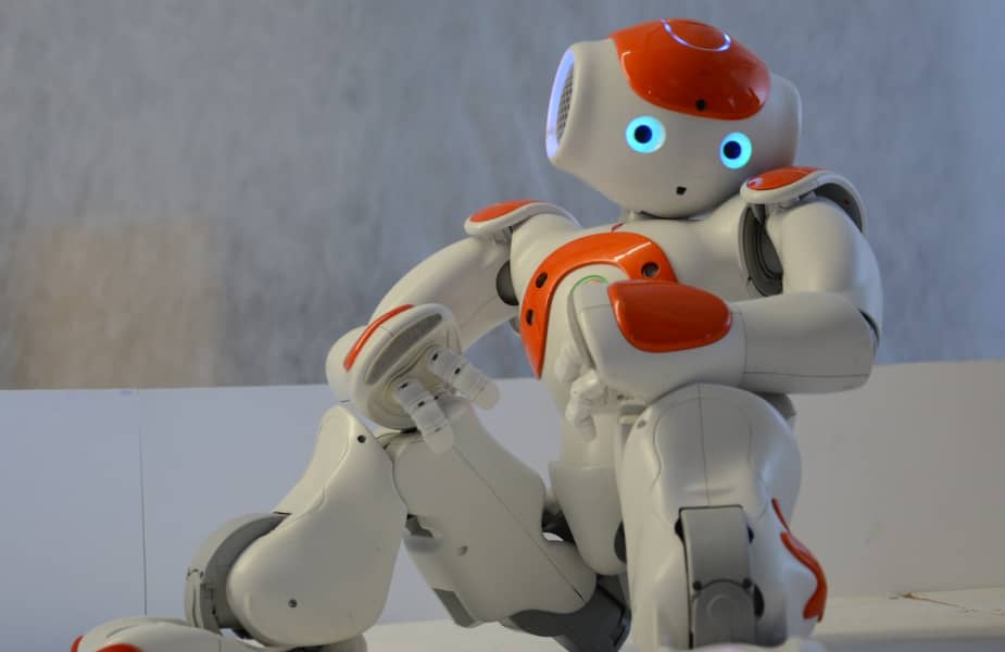 White and orange friendly robot sitting