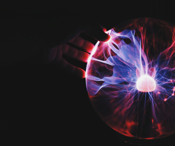 Hand placed on a plasma globe